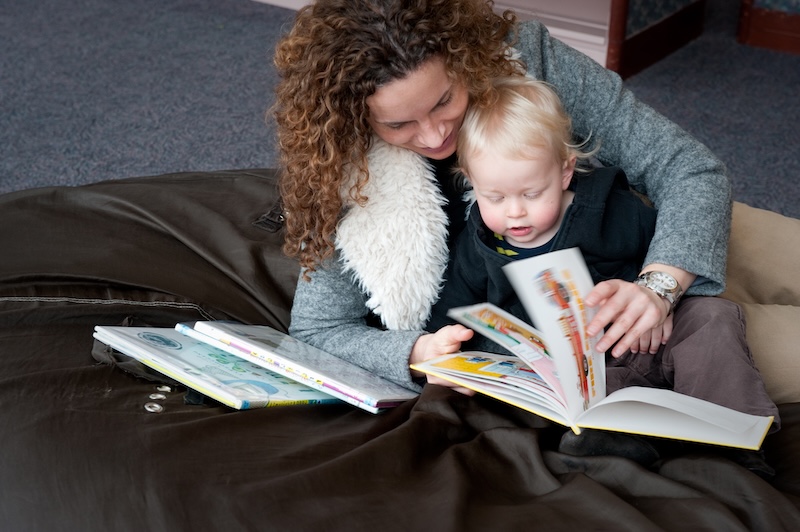 Woman reading book with toddler